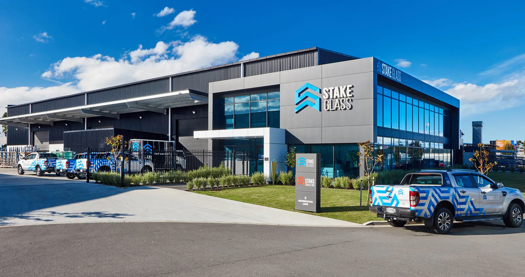 The Stake Glass premises, with branded vehicles parked outside