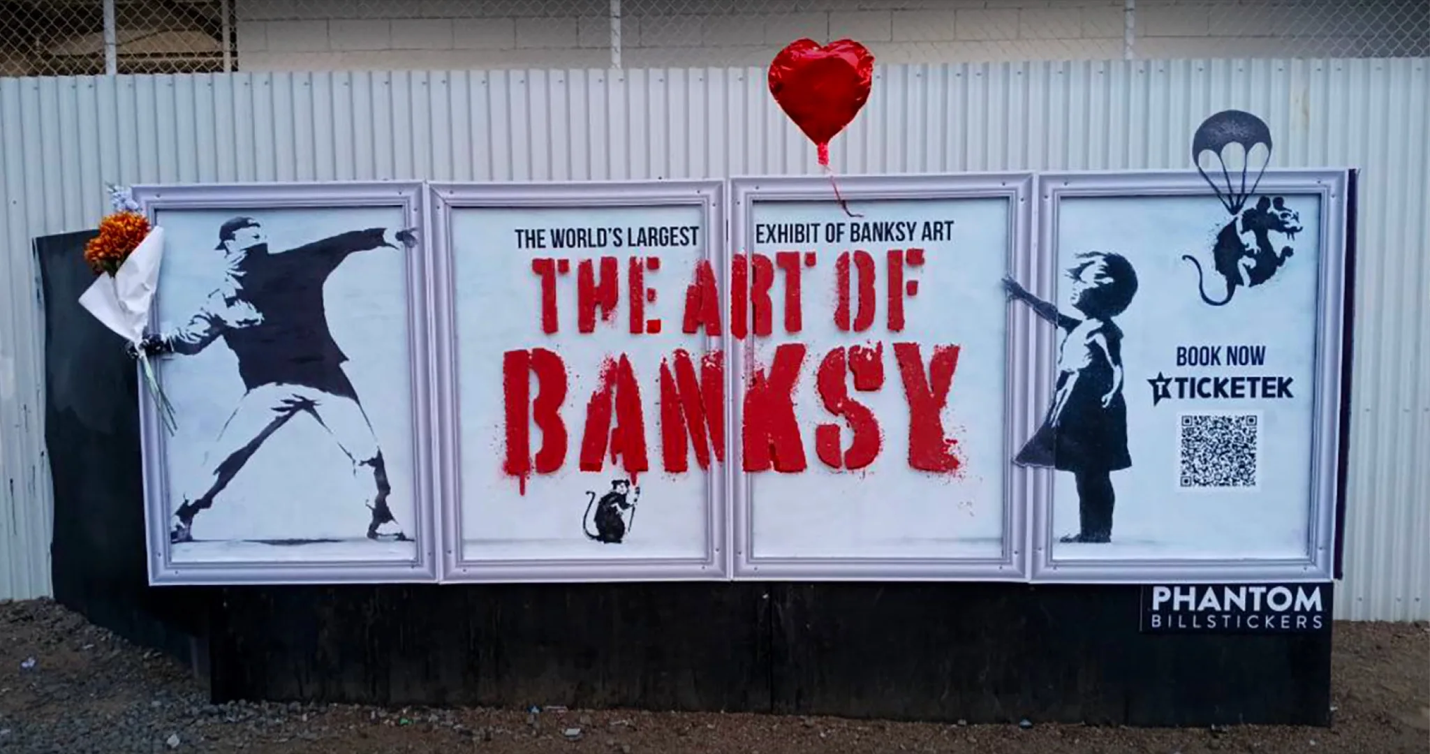 The Art of Banksy street poster with a red heart balloon attached